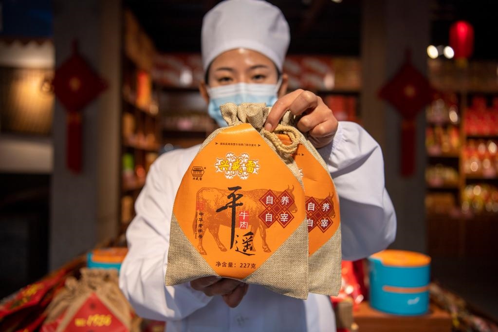 1月27日，在平遙古城南大街的一家平遙牛肉店內(nèi)，工作人員展示一款牛肉產(chǎn)品。新華社記者 楊晨光 攝