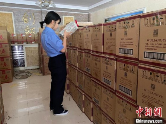 資料圖為檢察人員核對查獲的假冒品牌白酒。青海省人民檢察院供圖