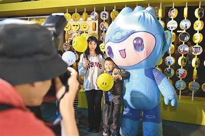 5月7日，在浙江省杭州市湖濱步行街“3D笑臉墻”前，攝影師為游客與杭州亞運會吉祥物之一“宸宸”拍攝合影。