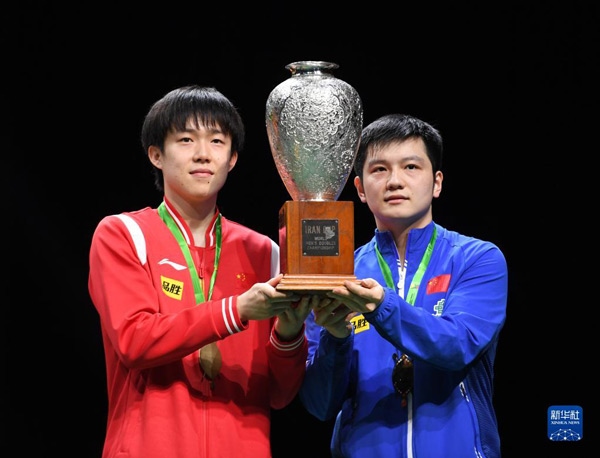 5月27日，樊振東（右）/王楚欽在頒獎儀式上高舉獎杯慶祝。當(dāng)日，在南非德班進行的2023年世界乒乓球錦標(biāo)賽男雙決賽中，中國組合樊振東/王楚欽以3比0戰(zhàn)勝韓國組合張禹珍/林鐘勛，奪得冠軍。新華社記者 李亞輝攝