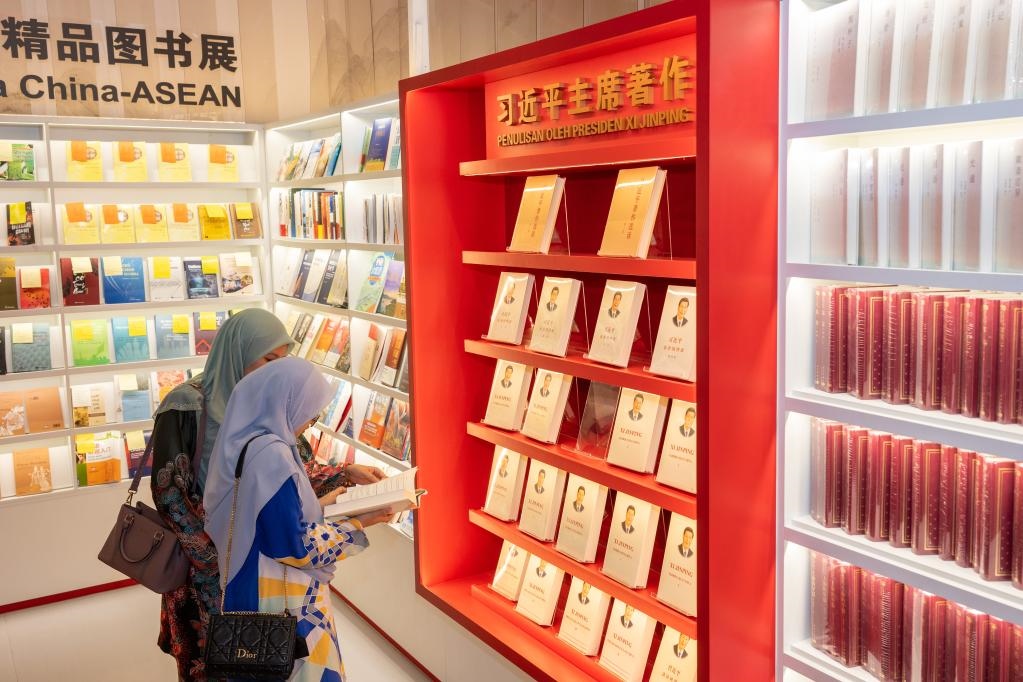 5月30日，兩名讀者在馬來西亞吉隆坡國際書展中國主賓國活動現(xiàn)場閱讀習(xí)近平主席著作。新華社記者朱煒攝