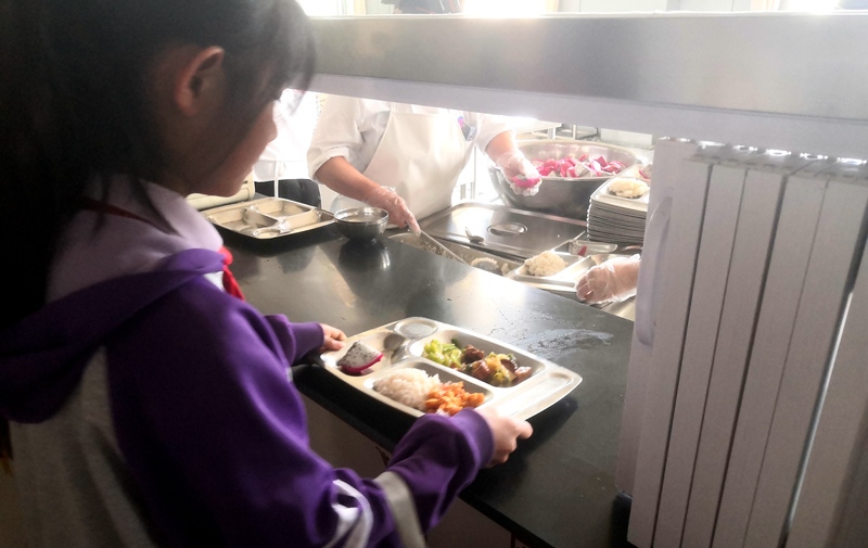 伊金霍洛旗第一小學(xué)學(xué)生正在打飯，今天的飯菜是三菜一湯外加水果，學(xué)生可以多次盛取，吃飽為止。人民網(wǎng)記者 孫博洋攝