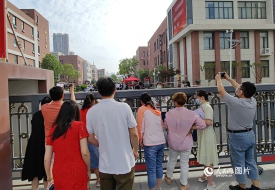 6月7日，武漢市第三中學(xué)考點(diǎn)，考生進(jìn)場后，家長在柵欄外用手機(jī)拍攝自己的孩子。人民網(wǎng)記者 郭婷婷攝