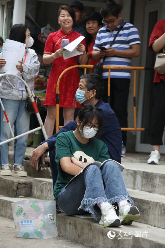 6月7日，沈陽市第一中學(xué)，學(xué)子靠在父親身邊做最后的沖刺。人民網(wǎng) 周頌雪攝