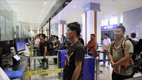6月13日，乘坐中老鐵路國際旅客列車的旅客在磨憨邊檢大廳排隊(duì)候檢。李揚(yáng) 攝