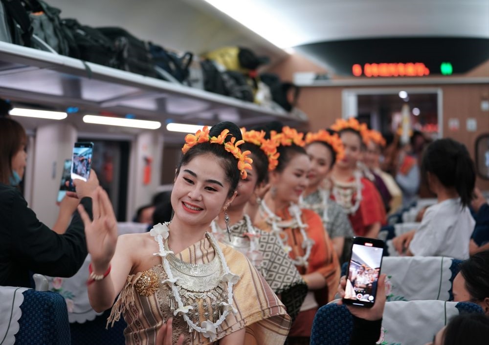 2023年4月13日，老撾工作人員在D887次國(guó)際旅客列車上表演。當(dāng)日，中老鐵路從中國(guó)昆明南站、老撾萬(wàn)象站雙向?qū)﹂_(kāi)D887次和D888次國(guó)際旅客列車，兩地乘火車可當(dāng)日通達(dá)。中老鐵路是高質(zhì)量共建“一帶一路”的標(biāo)志性工程。新華社記者 邢廣利 攝