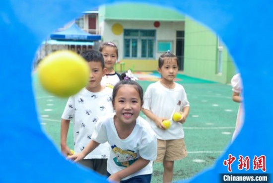 在肥西縣山南鎮(zhèn)中心幼兒園，孩子們在玩布洞投球游戲。陳家樂 攝