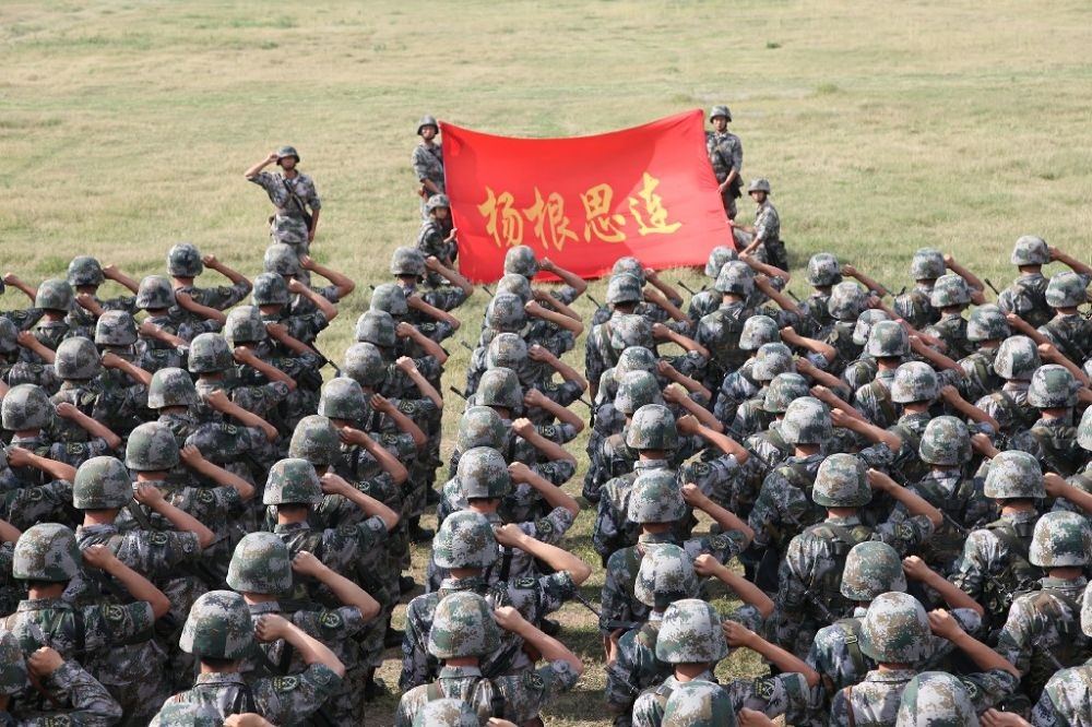 ↑“楊根思連”官兵執(zhí)行任務(wù)前向連旗宣誓（資料照片）。新華社發(fā)