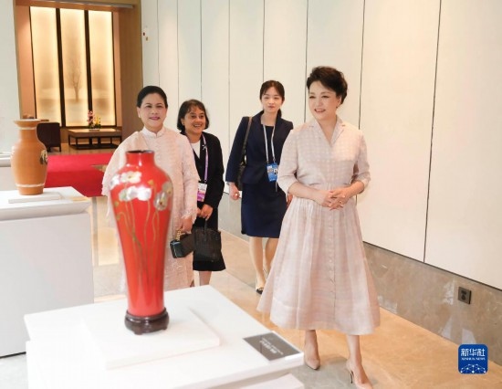7月27日下午，國(guó)家主席習(xí)近平夫人彭麗媛在四川成都會(huì)見陪同印度尼西亞總統(tǒng)佐科來華出席第31屆世界大學(xué)生夏季運(yùn)動(dòng)會(huì)開幕式并訪華的總統(tǒng)夫人伊莉亞娜。這是彭麗媛和伊莉亞娜欣賞成都特色非遺工藝品。新華社記者 丁林 攝