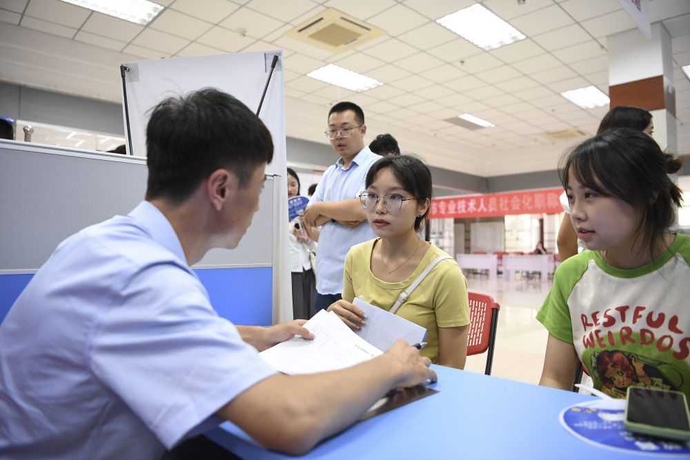 2023年7月29日，“揚就業(yè)之帆，啟夢想之旅”2023年寧夏（銀川）離校未就業(yè)高校畢業(yè)生招聘會在寧夏（銀川）人力資源服務產業(yè)園舉行。求職者（右）在招聘會現場與用人單位交流。新華社記者 馮開華 攝