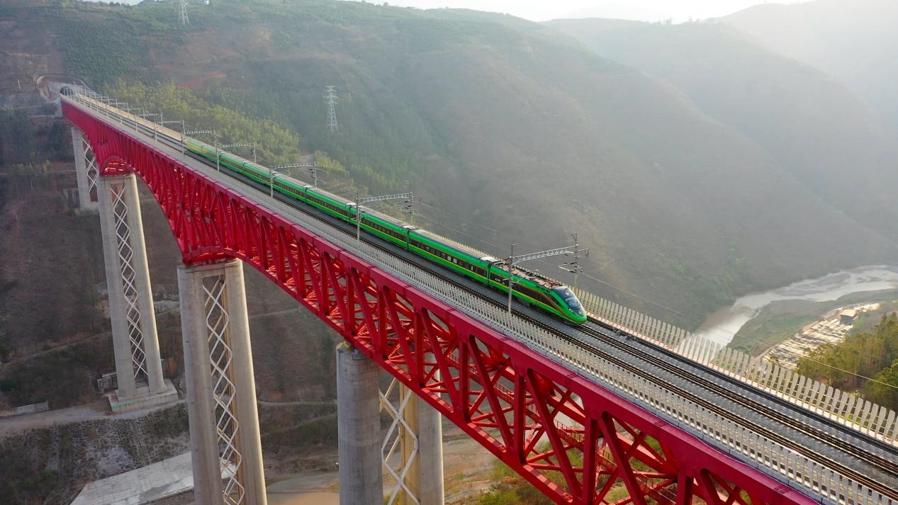 中老鐵路國(guó)際旅客列車在云南省境內(nèi)的元江特大橋上飛馳。姚巍攝