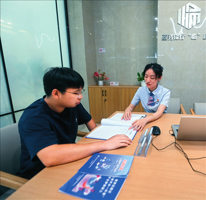 在杭州市臨安區(qū)政務(wù)服務(wù)中心的“為企服務(wù)中心”，黨員志愿者（右）解答企業(yè)主的疑問（2023年7月7日攝）。徐昱攝/本刊