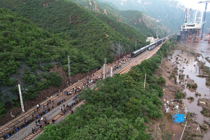8月2日，受困列車(chē)旅客在救援人員幫助下徒步趕往轉(zhuǎn)運(yùn)客車(chē)（無(wú)人機(jī)照片）。新華社記者 張晨霖 攝
