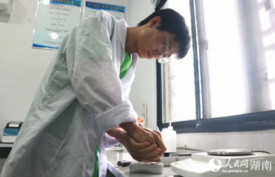 吳健筆在獼猴桃科技小院實(shí)驗(yàn)室測(cè)量水果糖分。 人民網(wǎng)記者 劉賓攝