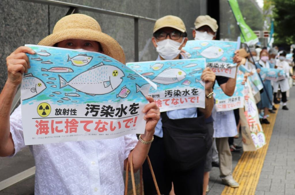 8月24日，日本民眾手持“不要將污染水扔進(jìn)大?！钡葮?biāo)語在東京電力公司總部前集會，抗議日本政府和東電公司無視民意啟動核污染水排海。新華社記者楊光攝