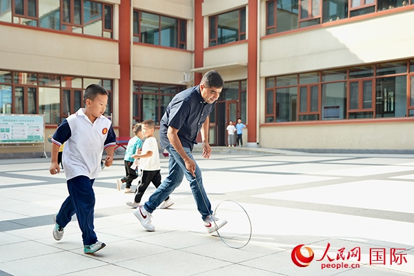 來(lái)自巴基斯坦的沙杰在滾鐵環(huán)。人民網(wǎng) 盧鵬宇攝