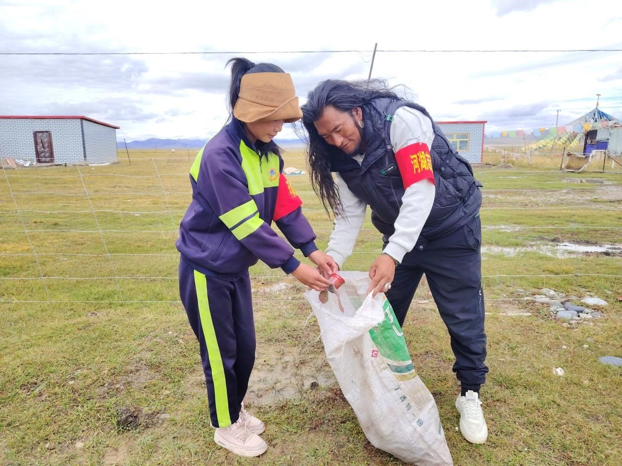 玉樹州稱多縣珍秦鎮(zhèn)河湖志愿者才培和他女兒更求拉毛在清掃垃圾。受訪者供圖