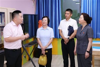 圖③：“小公民法律課堂”開講前，全國人大代表殷其龍（右二）、重慶市人大代表李自玲（左二）聽取楊家坪中學負責人關于未成年人思想教育工作情況的介紹。