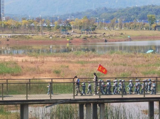 10月24日，秋游的幼兒園小朋友在老師帶領(lǐng)下走在清水塘公園里的木橋上。本報記者 常雯宜攝