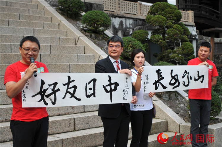 東京中國(guó)文化中心主任羅玉泉展示其為本次活動(dòng)書寫的題詞“中日友好，山高水長(zhǎng)”。人民網(wǎng) 蔣曉辰攝