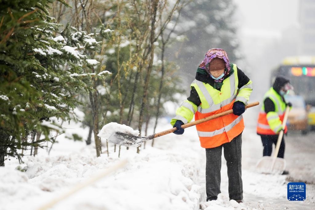 11月16日，環(huán)衛(wèi)工人在清理道路上的積雪。當(dāng)日，黑龍江哈爾濱市迎來雨雪天氣。新華社記者 王建威 攝