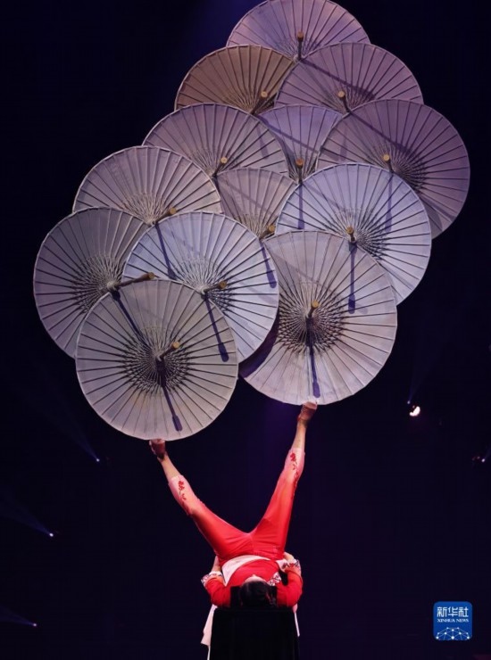 12月8日，演員在法國(guó)巴黎舉行的中國(guó)雜技“奇妙之夜”演出上表演《蹬傘》。新華社記者 高靜 攝