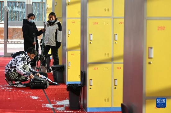 12月21日，游客在滑雪服務(wù)大廳整理滑雪裝備。