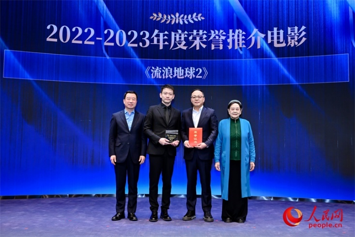 著名電影藝術(shù)家、事業(yè)家王曉棠（右一）和中國文聯(lián)書記處書記張宏（左一）為《流浪地球2》出品人、總監(jiān)制、總制片人傅若清（右二）與導(dǎo)演郭帆（左二）頒發(fā)“2022-2023年度榮譽推介電影”