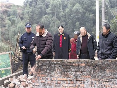  圖③：庭審結(jié)束后，在法官的見證下，陳某在院壩邊重新開鑿一條通道。