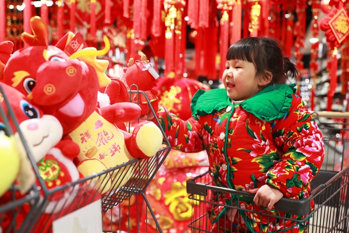 1月23日，在貴州省黔東南苗族侗族自治州岑鞏縣一家超市，小朋友在家人的帶領(lǐng)下選購(gòu)龍年毛絨玩具。新華社發(fā)（唐鵬攝）