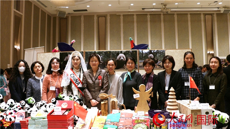 中國駐日本大使吳江浩夫人丁玥（左五）與使館人員在展位前合影留念。人民網(wǎng) 許可攝