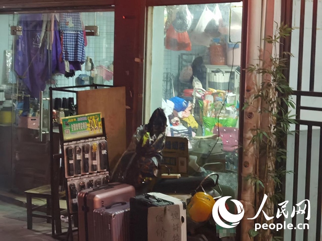 南寧“城中村”一裁縫鋪老板將電線(xiàn)從店內(nèi)拉出為電動(dòng)自行車(chē)充電。人民網(wǎng) 覃心攝