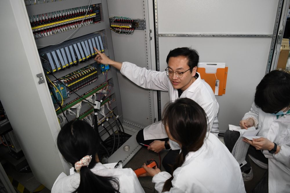2024年4月6日，在位于安徽合肥的中國(guó)科學(xué)技術(shù)大學(xué)，安徽省先進(jìn)功能高分子薄膜工程實(shí)驗(yàn)室團(tuán)隊(duì)成員在檢修自主研制的高分子薄膜原位雙向拉伸實(shí)驗(yàn)設(shè)備的電氣控制系統(tǒng)。
