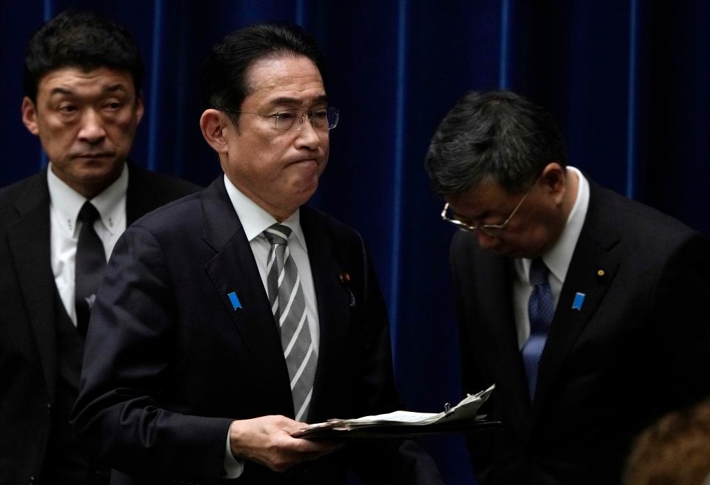 2023年12月13日，日本首相岸田文雄（中）在日本東京首相官邸召開(kāi)記者會(huì)后走過(guò)時(shí)任內(nèi)閣官房長(zhǎng)官松野博一（右）。新華社發(fā)（Pool圖片，弗蘭克·羅比雄攝）
