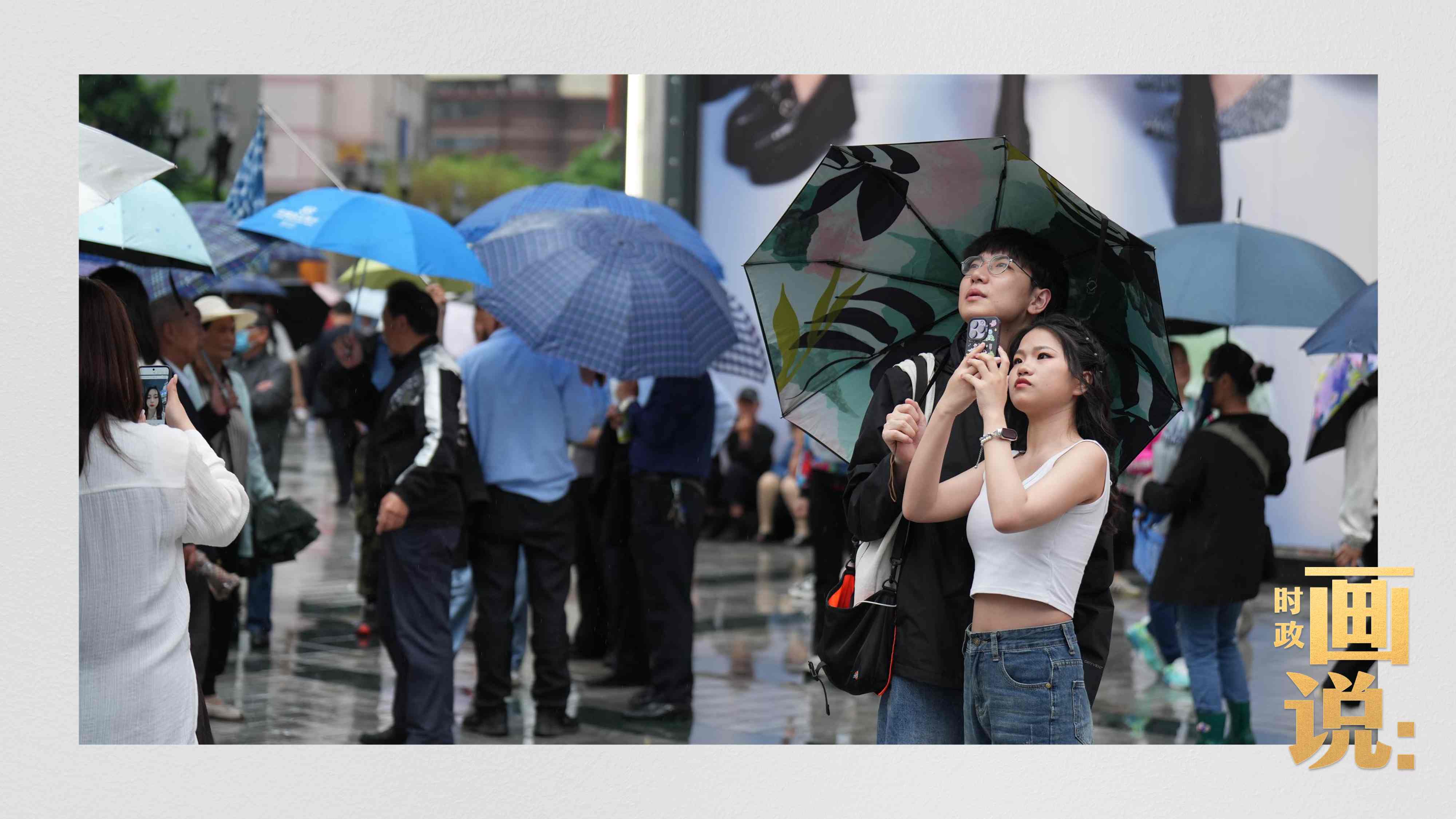 △細(xì)雨中的解放碑步行街，騎在父親肩膀的小女孩好奇張望。