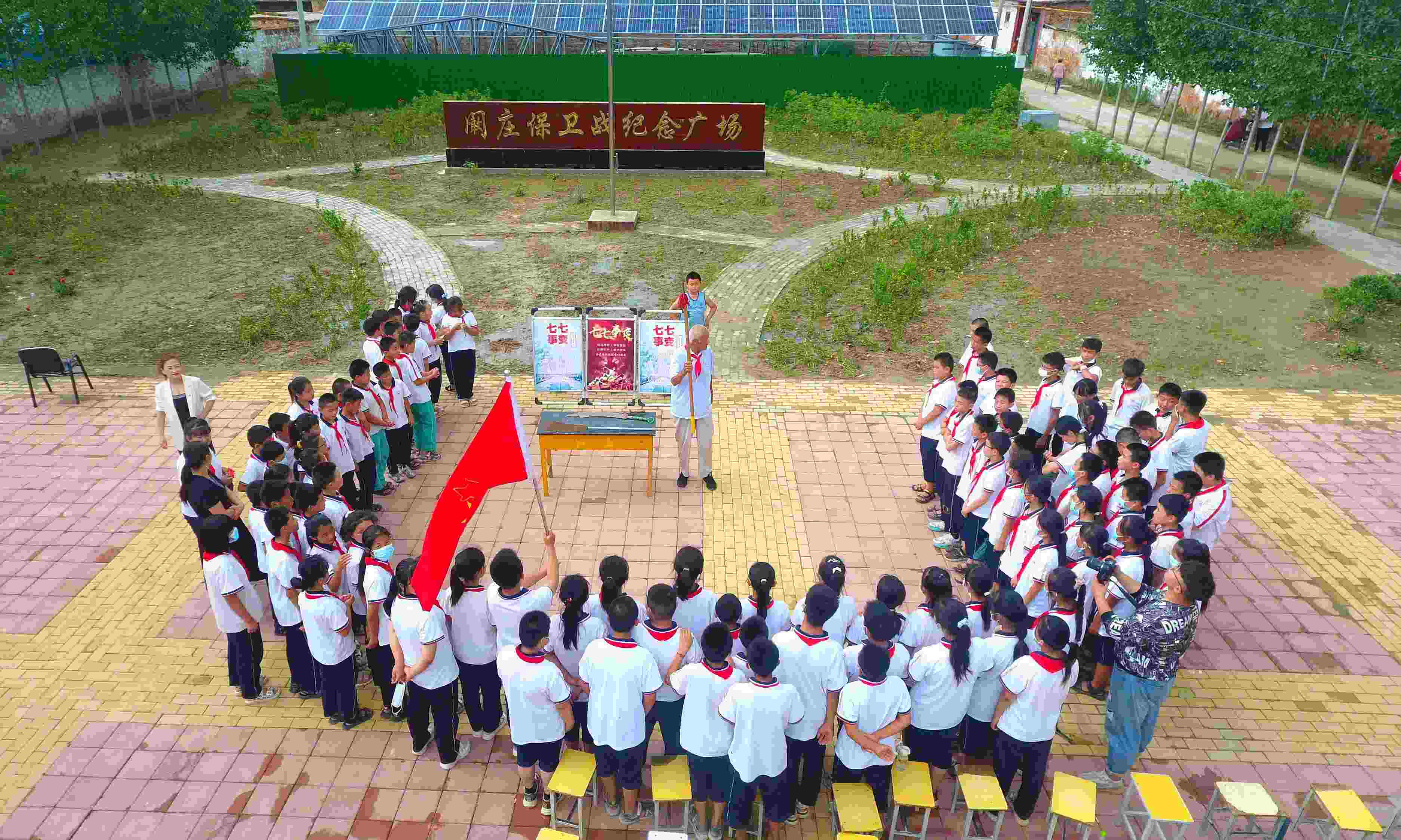 2022年7月6日，山東省聊城市，在茌平區(qū)菜屯鎮(zhèn)闞莊村的闞莊保衛(wèi)戰(zhàn)紀(jì)念廣場，闞莊保衛(wèi)戰(zhàn)親歷者王光木老人為小學(xué)生們講述抗戰(zhàn)故事，展示大刀、長矛。