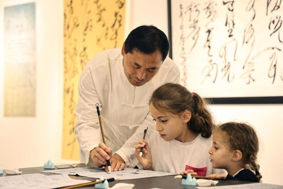 中國(guó)書(shū)法老師帶領(lǐng)現(xiàn)場(chǎng)觀眾體驗(yàn)書(shū)法。拉巴特中國(guó)文化中心供圖