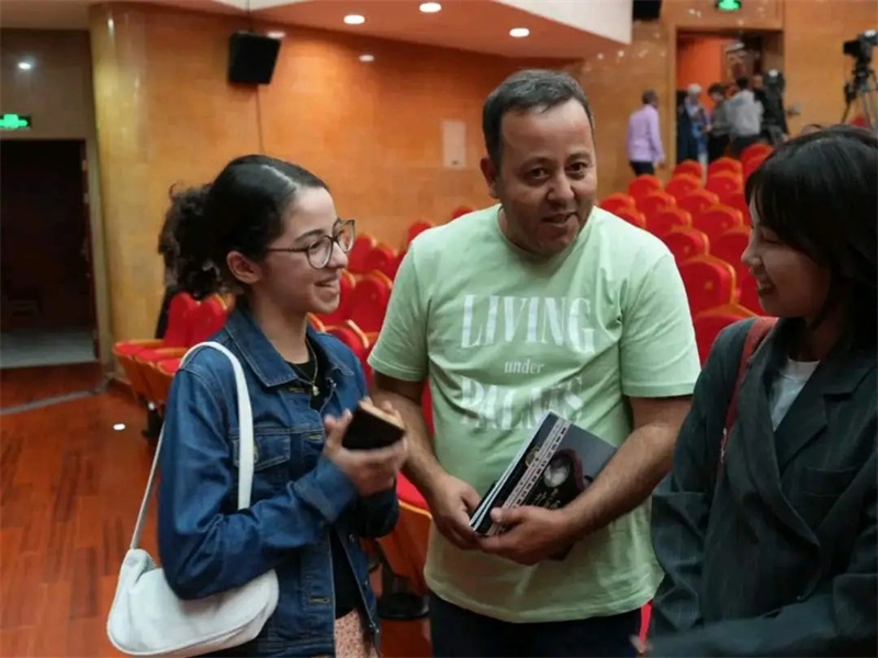 阿爾及利亞市民拉納·艾薩尼和她父親現(xiàn)場聆聽中阿交響樂演出 。蘇州交響樂團(tuán)供圖