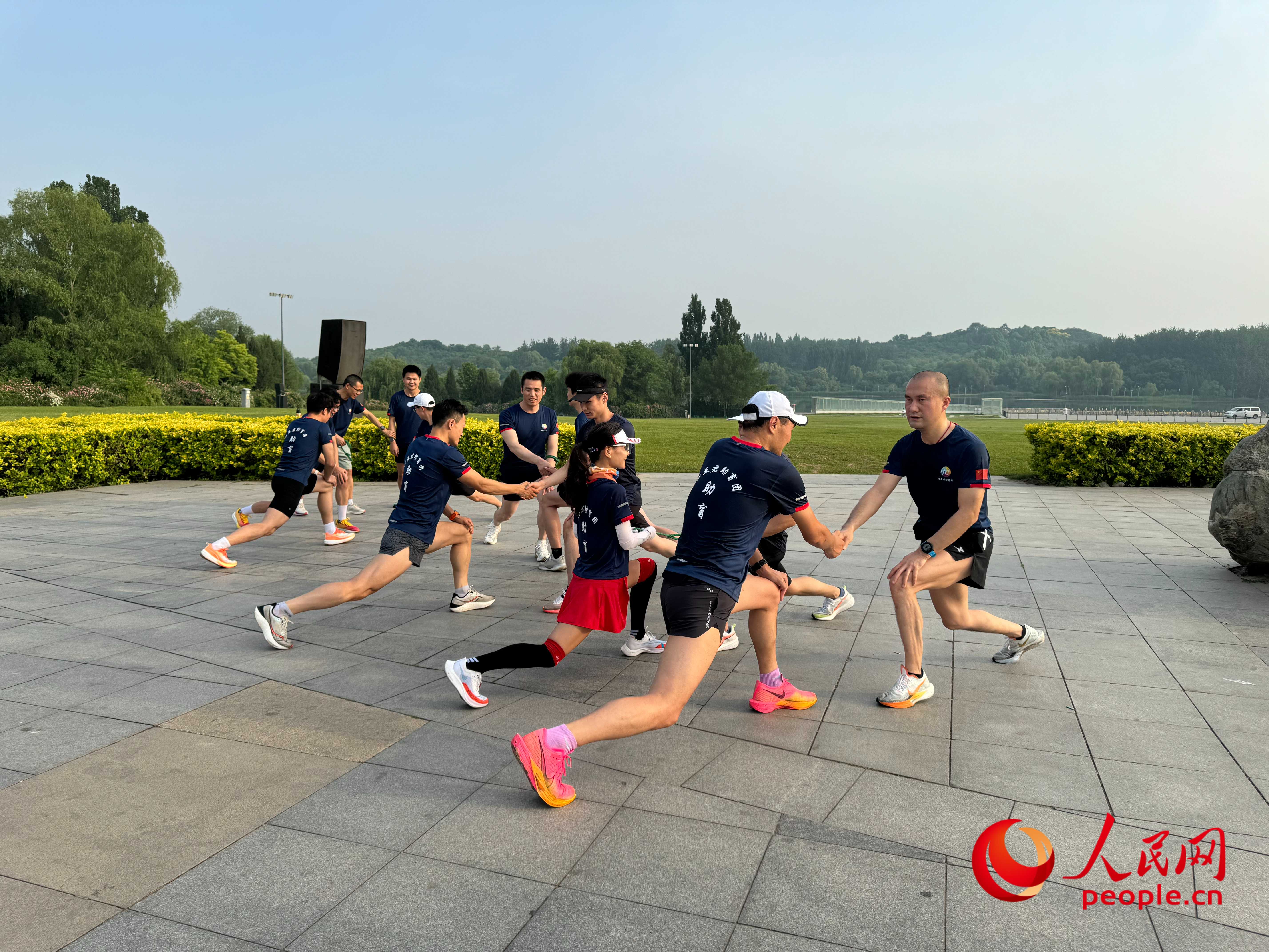 盲人和志愿者做跑步前準(zhǔn)備。人民網(wǎng) 周靜圓攝
