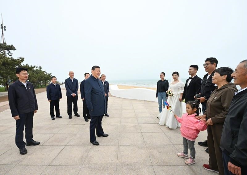 5月22日，在山東日照考察調(diào)研的習(xí)近平總書記來到陽光海岸綠道，同市民游客親切交流。