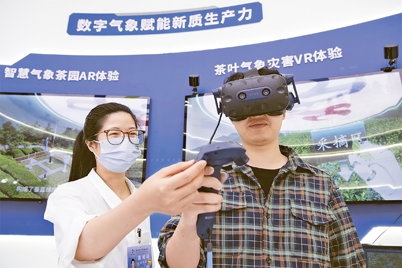 2024年5月23日，第七屆數(shù)字中國建設(shè)峰會現(xiàn)場體驗區(qū)在福州海峽國際會展中心向?qū)I(yè)觀眾開放。本次現(xiàn)場體驗區(qū)圍繞本屆峰會主題“釋放數(shù)據(jù)要素價值，發(fā)展新質(zhì)生產(chǎn)力”，設(shè)置“數(shù)字惠民”、“數(shù)字能力”、“數(shù)字基礎(chǔ)”、“數(shù)字生態(tài)”、“數(shù)字賦能”五大板塊。圖為一名觀眾（右）在數(shù)字氣象賦能新質(zhì)生產(chǎn)力展臺上進行體驗。 新華社記者 魏培全/攝