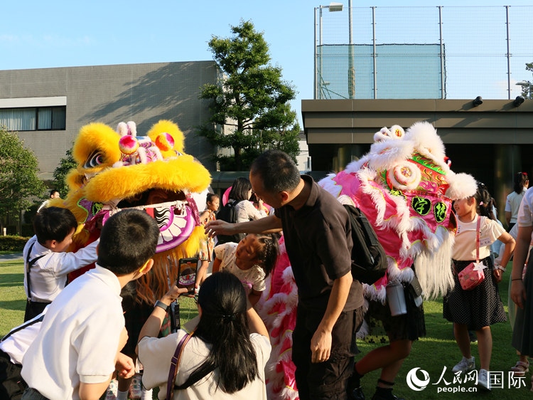 孩子們好奇地圍觀舞獅。人民網(wǎng) 許可攝