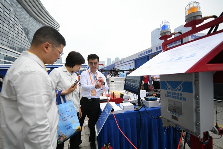 6月16日，在全國“安全宣傳咨詢?nèi)铡敝鲌龌顒由?，四川省安全科學(xué)技術(shù)研究院工作人員（右一）向參觀者介紹“有限空間作業(yè)實時風(fēng)險管控系統(tǒng)”。新華社記者胥冰潔攝