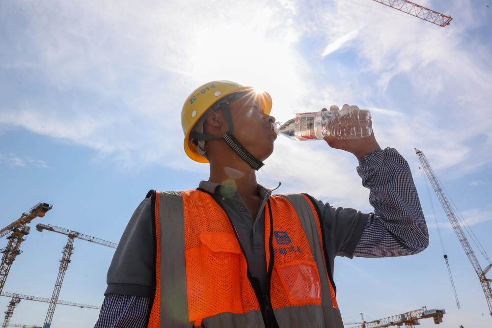 6月18日，在江蘇省無錫市奧體三期項(xiàng)目施工現(xiàn)場，中建二局工人在喝水解暑。新華社發(fā)（朱吉鵬 攝）
