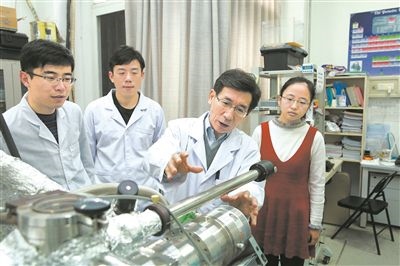2017年10月，清華大學(xué)低維量子物理國(guó)家重點(diǎn)實(shí)驗(yàn)室，薛其坤（左三）與學(xué)生討論實(shí)驗(yàn)工作。 苑潔攝