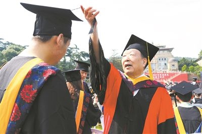 2017年6月22日，李德仁（右一）參加武漢大學(xué)畢業(yè)典禮并為畢業(yè)生撥穗。