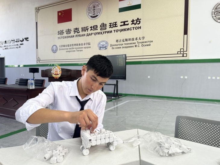 在塔吉克斯坦魯班工坊內(nèi)，學(xué)員正在操作能力源創(chuàng)新套件。本報(bào)記者 屈佩 攝