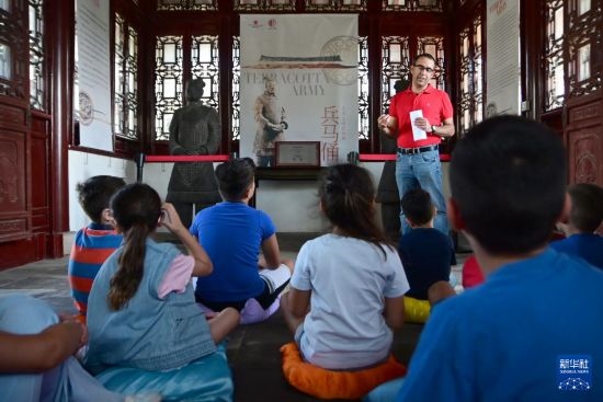 7月4日，在馬耳他桑塔露琪亞市的中國古典園林“靜園”，人們聆聽關(guān)于兵馬俑的講解。新華社發(fā)（喬納森·博格 攝）