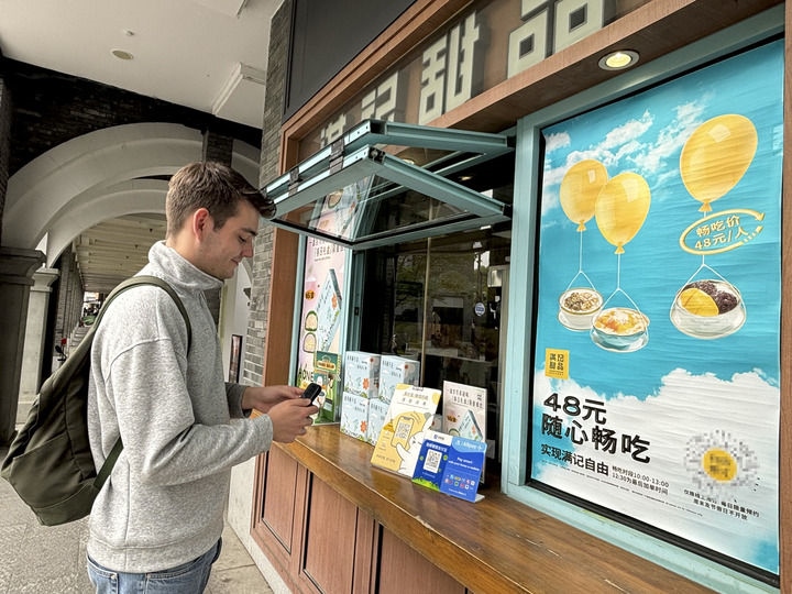 來自德國的留學生理查德在杭州西湖邊一家商鋪使用支付寶掃碼支付（2024年4月11日攝）。新華社發(fā)