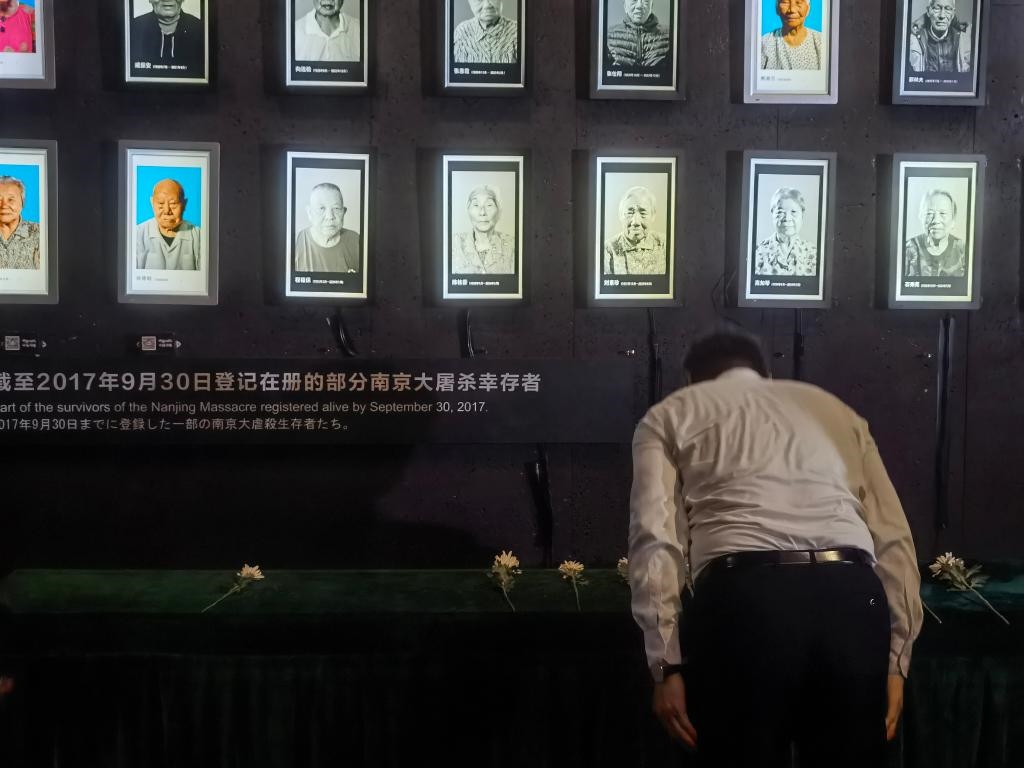 7月18日，人們向離世的南京大屠殺幸存者獻(xiàn)花、鞠躬。新華社記者邱冰清 攝